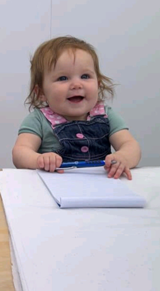Young child sitting behind the counter at Salt & Honey Feilding, playfully pretending to serve customers inside the boutique.