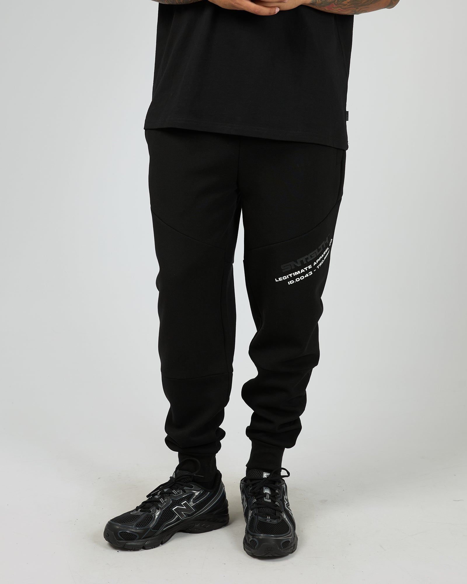 Male wearing black St Goliath jogger pants with St Goliath white text on a white background