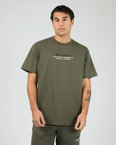 Man wearing a St Goliath Khaki green t-shirt with text on a plain background