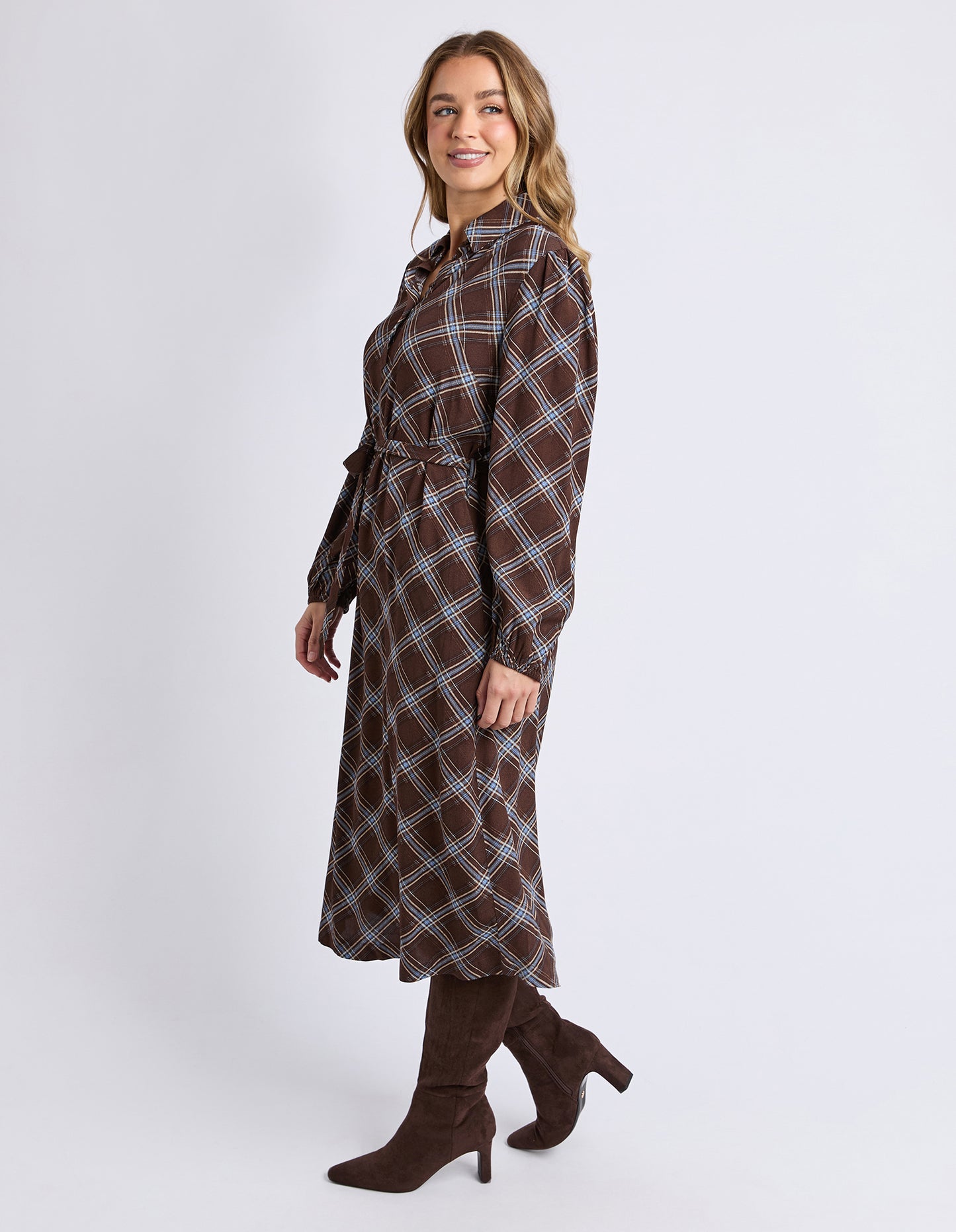 Woman wearing a Foxwood brown and blue plaid dress on a white background
