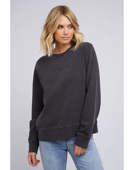 Woman wearing a All About Eve washed black sweatshirt with AAE Logo on a light gray background