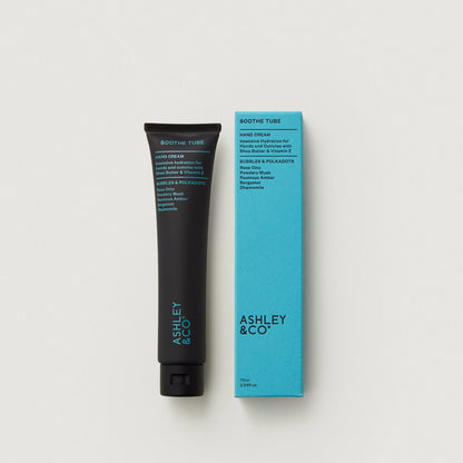 Hand cream tube and packaging with 'Ashley & Co' branding on a light gray background
