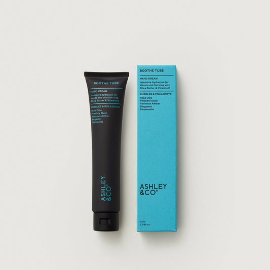 Hand cream tube and packaging with 'Ashley & Co' branding on a light gray background