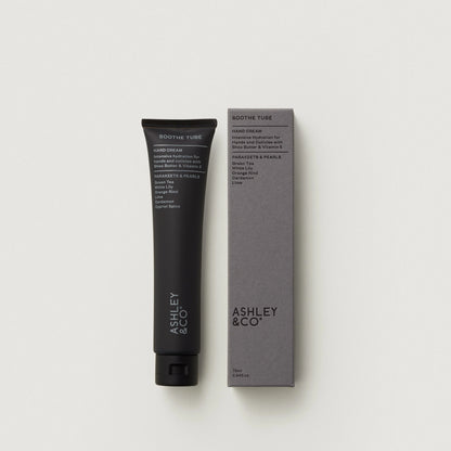 Hand cream tube and packaging with 'Ashley & Co' branding on a light gray background