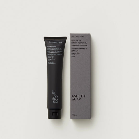 Hand cream tube and packaging with 'Ashley & Co' branding on a light gray background