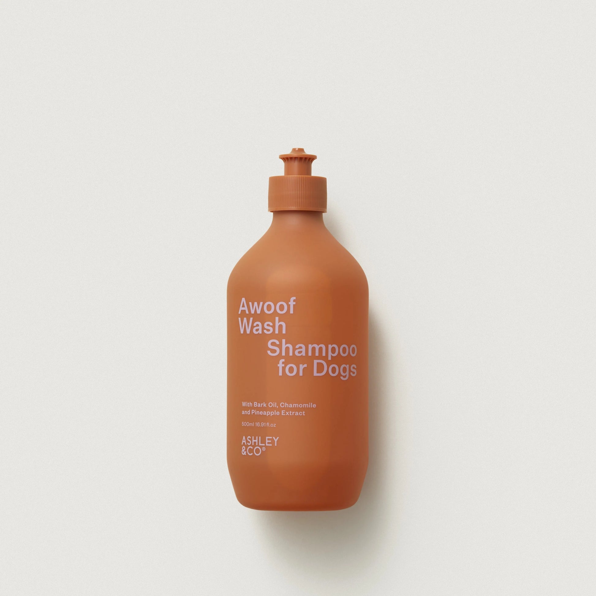 Orange bottle of 'Awoof Wash Shampoo for Dogs' by Ashley & Co on a light gray background