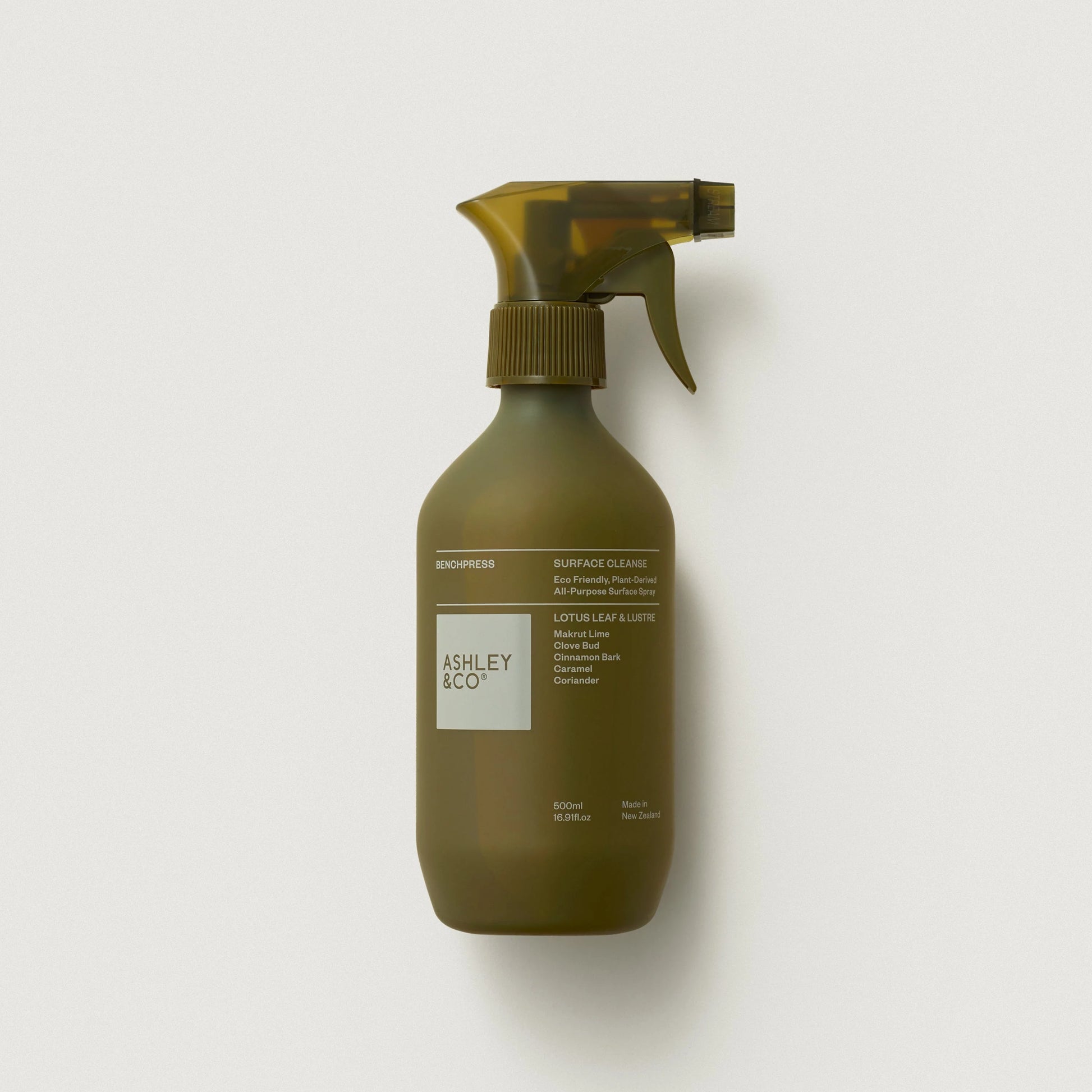 Olive green spray bottle with 'Ashley & Co.' label on a light gray background