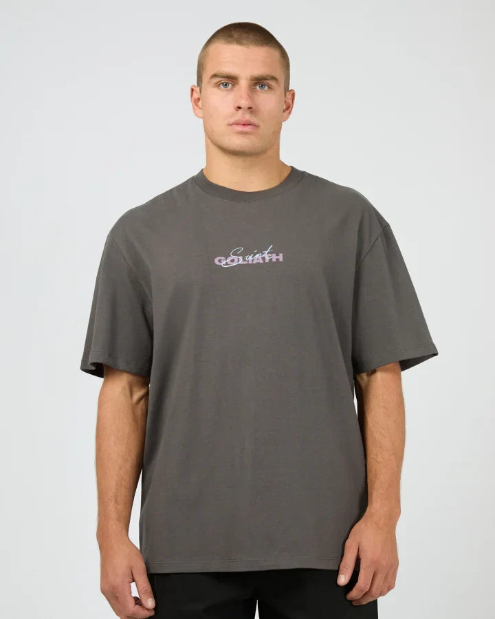 Man wearing a gray t-shirt with a St Goliath logo on a plain background