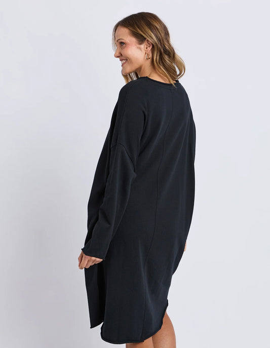 Back view of the Elm Gab Dress in Black with raw hem detailing and relaxed silhouette.