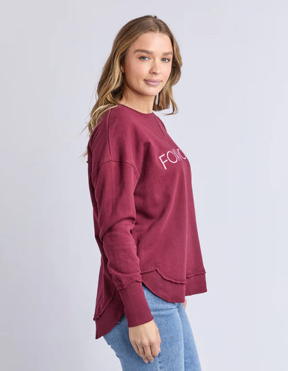 Side profile of the Foxwood Simplified Metallic Crew in Port — curved hi‑lo hem

